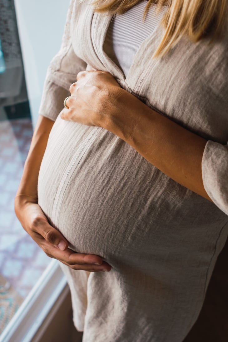 Pregnant Woman in Dress Holding Belly